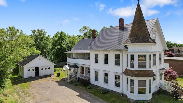 123 Main St, Newport, ME 04953 - view of side of property with a chimney, an outbuilding, a garage, metal roof, and a standing seam roof