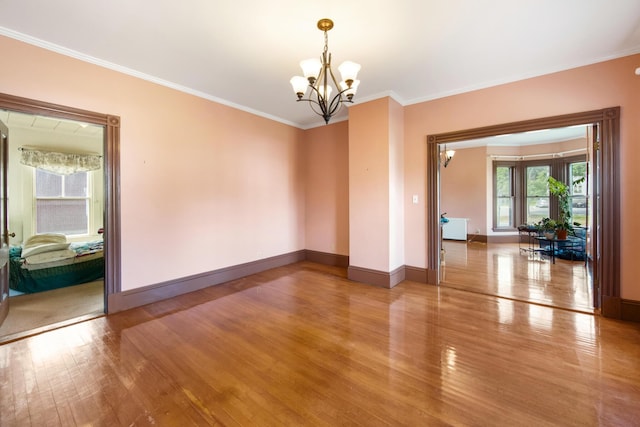 123 Main St, Newport, ME 04953 - empty room featuring a chandelier, light wood-type flooring, crown molding, and baseboards