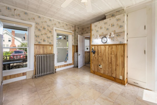 123 Main St, Newport, ME 04953 - unfurnished room featuring radiator heating unit, a wainscoted wall, an ornate ceiling, wallpapered walls, and ceiling fan