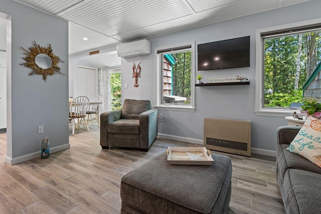 131 Temple Ave Unit 26, Old Orchard Beach, ME 04064 - living area featuring a wall mounted air conditioner, healthy amount of natural light, and wood finished floors