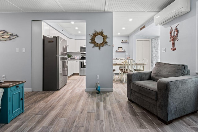 131 Temple Ave Unit 26, Old Orchard Beach, ME 04064 - living room with an AC wall unit, light wood finished floors, recessed lighting, and baseboards