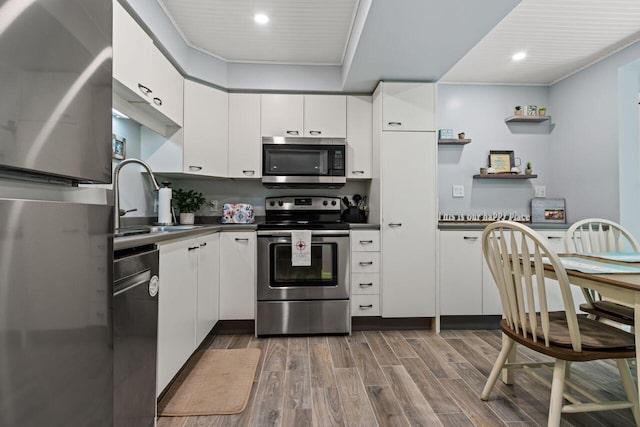 131 Temple Ave Unit 26, Old Orchard Beach, ME 04064 - kitchen with appliances with stainless steel finishes, a sink, dark countertops, dark wood-style floors, and white cabinetry
