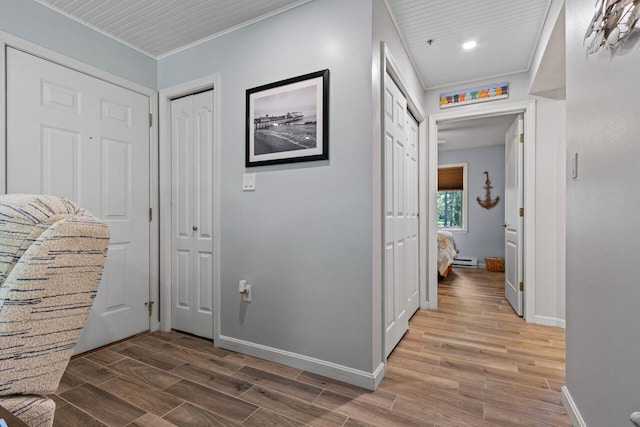 131 Temple Ave Unit 26, Old Orchard Beach, ME 04064 - corridor with baseboards, wood finished floors, a baseboard heating unit, and crown molding