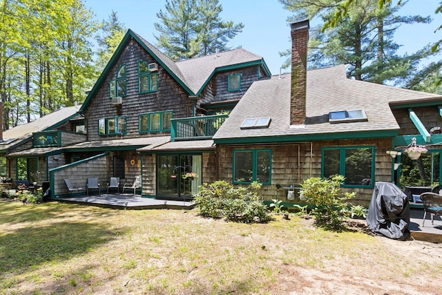 131 Temple Ave Unit 26, Old Orchard Beach, ME 04064 - rear view of house with a chimney, a yard, a patio area, a shingled roof, and a balcony