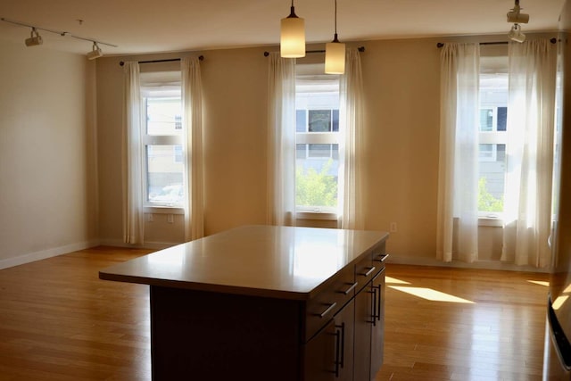 65 Munjoy St Unit 4, Portland, ME 04101 - kitchen with track lighting, light wood-type flooring, pendant lighting, a kitchen island, and baseboards
