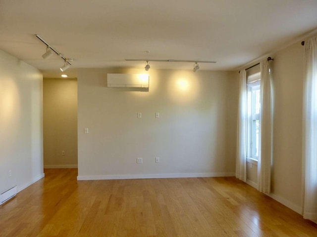 65 Munjoy St Unit 4, Portland, ME 04101 - unfurnished room featuring track lighting, a wall unit AC, light wood finished floors, and baseboard heating