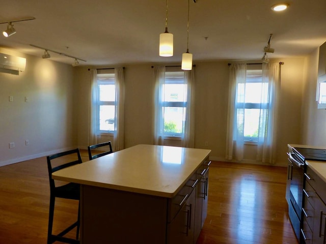 65 Munjoy St Unit 4, Portland, ME 04101 - kitchen featuring stainless steel range with electric stovetop, rail lighting, a wall mounted AC, wood finished floors, and light countertops