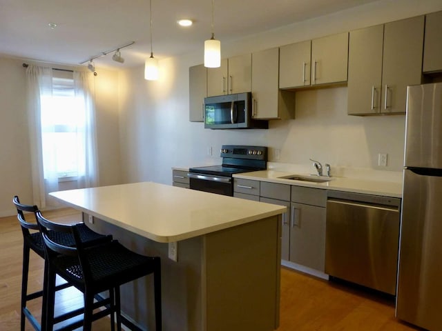 65 Munjoy St Unit 4, Portland, ME 04101 - kitchen featuring stainless steel appliances, a center island, gray cabinetry, light wood-style floors, and a breakfast bar