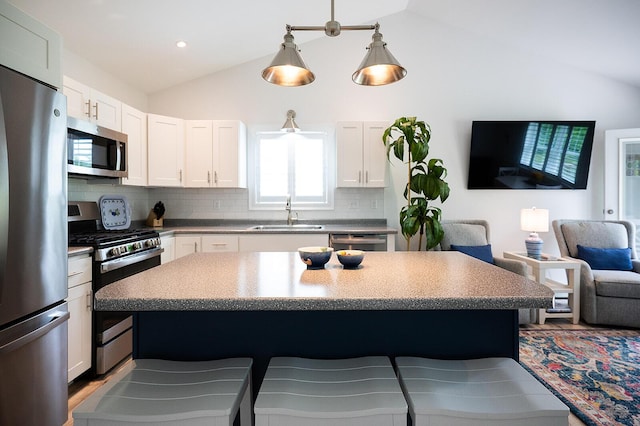11 Unity Ln Unit 11, Windham, ME 04062 - kitchen featuring stainless steel appliances, a sink, a breakfast bar area, tasteful backsplash, and white cabinets