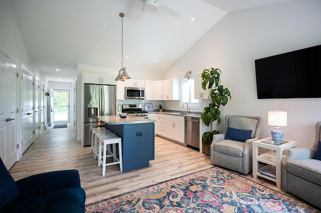 11 Unity Ln Unit 11, Windham, ME 04062 - kitchen with appliances with stainless steel finishes, open floor plan, a sink, a kitchen breakfast bar, and a kitchen island