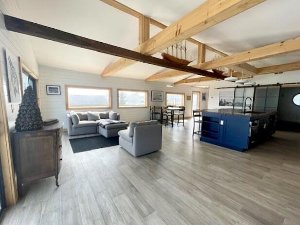 32 Water St, Lubec, ME 04652 - living room featuring beamed ceiling, a barn door, and light wood-style flooring