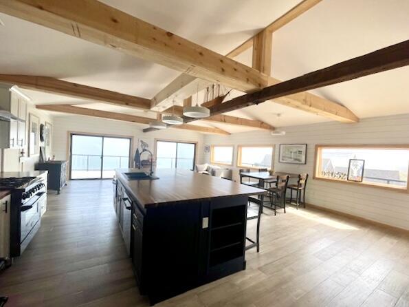32 Water St, Lubec, ME 04652 - kitchen with gas stove, dark cabinets, a sink, beam ceiling, and wood finished floors
