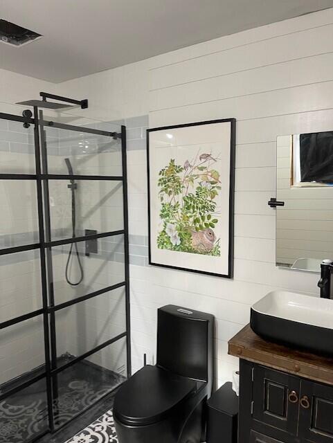 32 Water St, Lubec, ME 04652 - bathroom with a shower stall, vanity, toilet, and wood walls