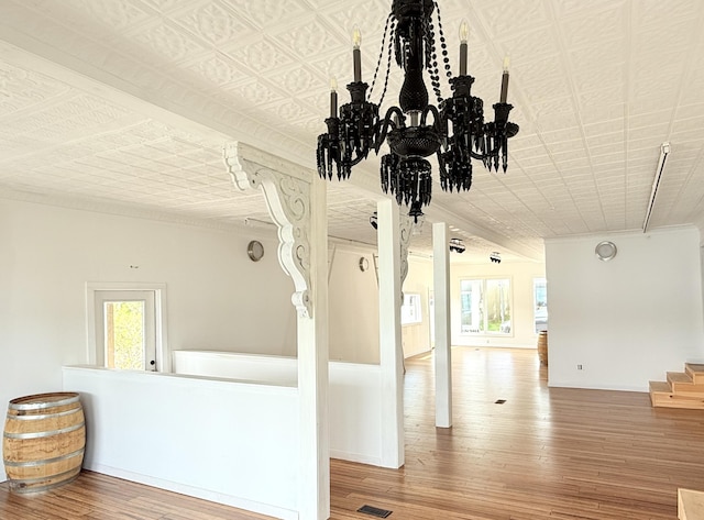 32 Water St, Lubec, ME 04652 - unfurnished living room with wood finished floors, a chandelier, ornamental molding, and stairs