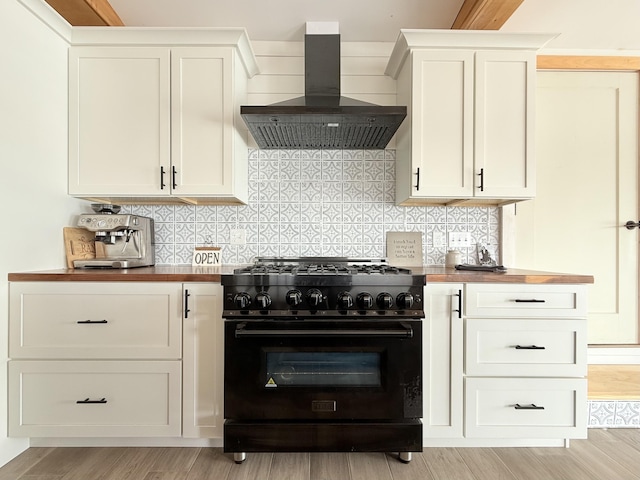 32 Water St, Lubec, ME 04652 - kitchen featuring gas stove, wall chimney exhaust hood, butcher block counters, and backsplash
