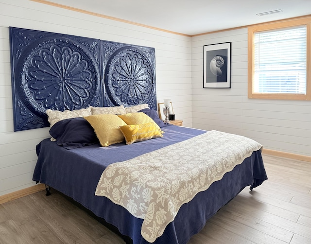 32 Water St, Lubec, ME 04652 - bedroom with wood finished floors, wood walls, and crown molding