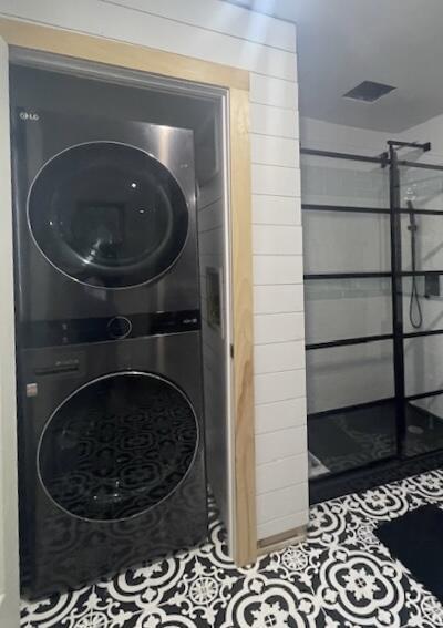 32 Water St, Lubec, ME 04652 - washroom featuring stacked washer / dryer and tile patterned flooring
