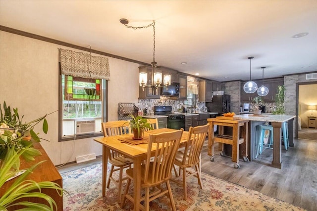 833 Sedgwick Ridge Rd, Sedgwick, ME 04676 - dining space with wood finished floors, a chandelier, cooling unit, and ornamental molding