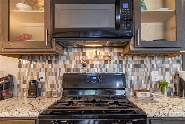 833 Sedgwick Ridge Rd, Sedgwick, ME 04676 - kitchen with black appliances, glass insert cabinets, light stone countertops, and backsplash