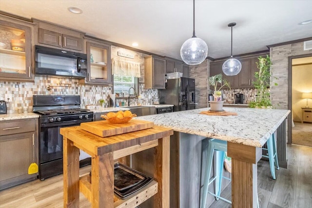 833 Sedgwick Ridge Rd, Sedgwick, ME 04676 - kitchen featuring black appliances, light wood-type flooring, tasteful backsplash, glass insert cabinets, and ornamental molding