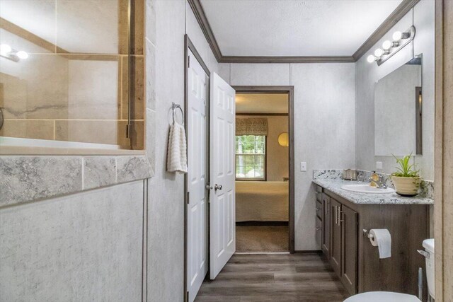 833 Sedgwick Ridge Rd, Sedgwick, ME 04676 - ensuite bathroom featuring ornamental molding, vanity, and wood finished floors