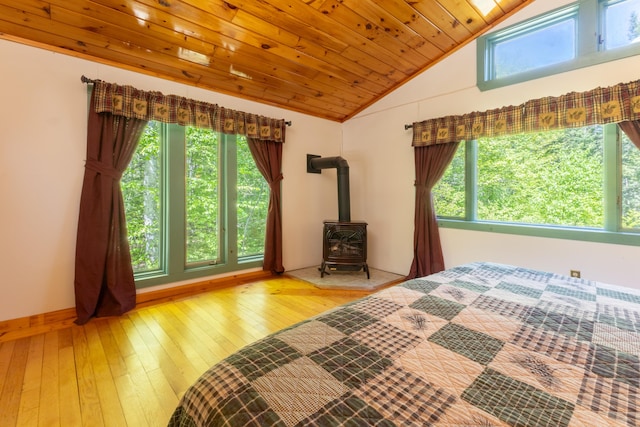200 Flanders Pond Rd, Sullivan, ME 04664 - bedroom with vaulted ceiling, multiple windows, a wood stove, wood ceiling, and hardwood / wood-style floors