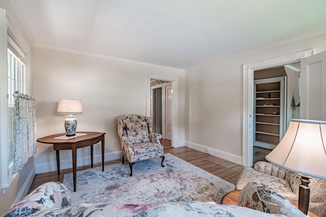 living room featuring baseboards, ornamental molding, and wood finished floors