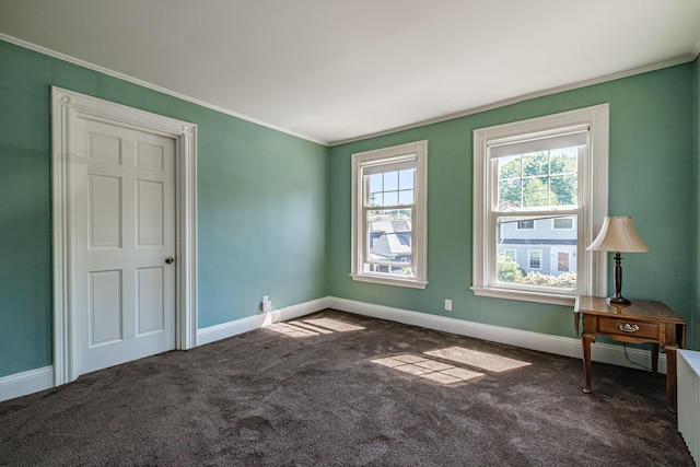 spare room featuring crown molding, carpet, and baseboards