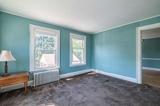 unfurnished room with radiator heating unit, crown molding, baseboards, and carpet