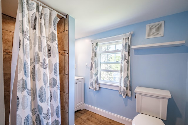 bathroom featuring wood finished floors, curtained shower, toilet, and vanity