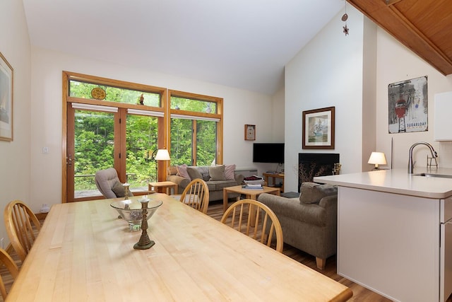2396 Hemlock Dr Unit 2396, Carrabassett Valley, ME 04947 - dining space with wood finished floors, vaulted ceiling, and a fireplace