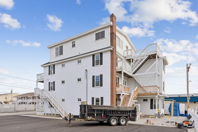 5 Kinney Ave Unit 303, Old Orchard Beach, ME 04064 - rear view of house featuring stairs and a chimney
