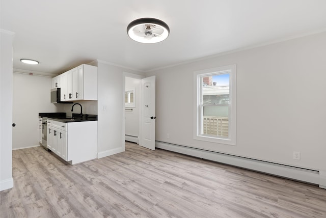 5 Kinney Ave Unit 303, Old Orchard Beach, ME 04064 - kitchen featuring a baseboard heating unit, ornamental molding, light wood-style floors, white cabinetry, and dark countertops