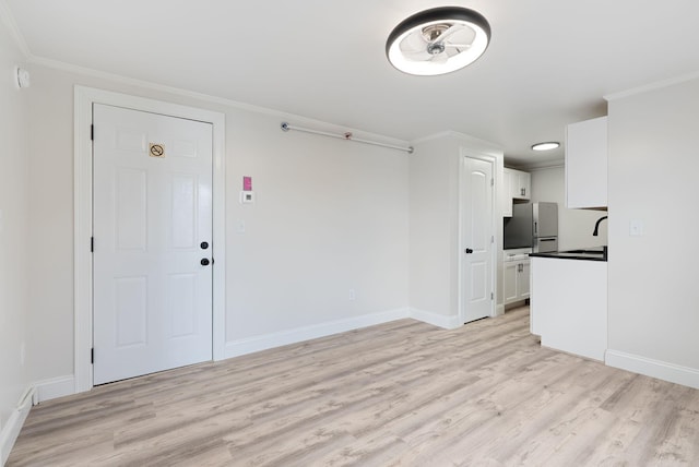 5 Kinney Ave Unit 303, Old Orchard Beach, ME 04064 - unfurnished living room with light wood finished floors, crown molding, baseboards, and a sink