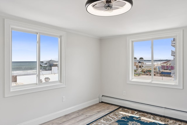 5 Kinney Ave Unit 303, Old Orchard Beach, ME 04064 - spare room with a baseboard heating unit, wood finished floors, healthy amount of natural light, baseboards, and ornamental molding