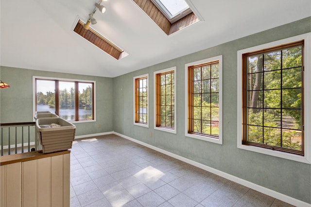 30 Otter Cove Ln, North Berwick, ME 03906 - spare room featuring a skylight, vaulted ceiling, track lighting, a water view, and tile patterned flooring