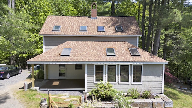 30 Otter Cove Ln, North Berwick, ME 03906 - back of house with roof with shingles, a chimney, and view of wooded area
