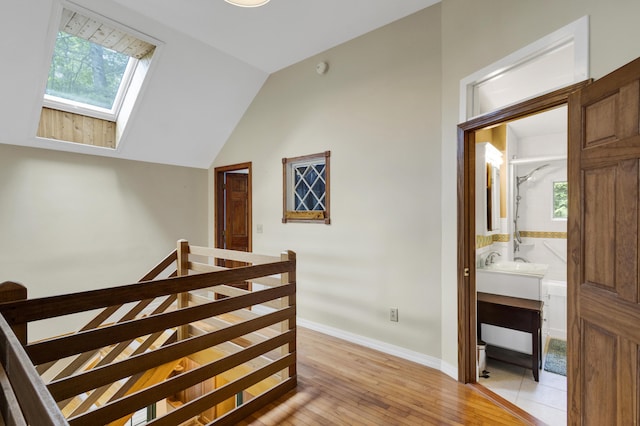 30 Otter Cove Ln, North Berwick, ME 03906 - hall with an upstairs landing, a skylight, light wood finished floors, vaulted ceiling, and baseboards