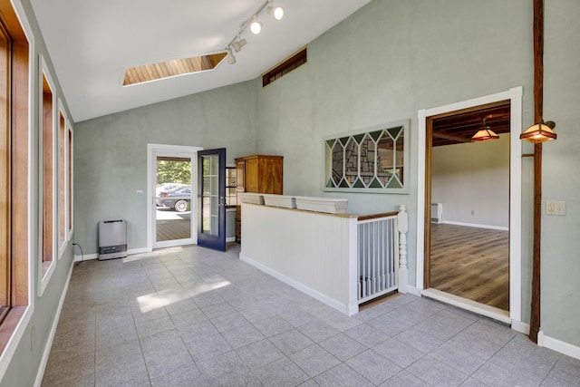 30 Otter Cove Ln, North Berwick, ME 03906 - unfurnished living room featuring high vaulted ceiling, tile patterned floors, a skylight, baseboards, and track lighting