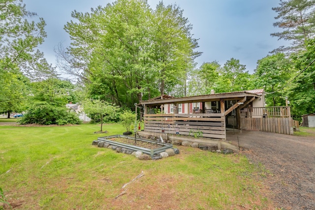 26 Knapp Ave, Milo, ME 04463 - view of front of property featuring a front yard, a chimney, a wooden deck, and a vegetable garden
