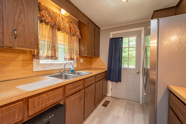 26 Knapp Ave, Milo, ME 04463 - kitchen featuring freestanding refrigerator, light wood finished floors, a sink, light countertops, and brown cabinets