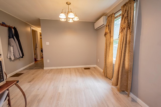 26 Knapp Ave, Milo, ME 04463 - spare room with an AC wall unit, light wood finished floors, a chandelier, ornamental molding, and baseboards