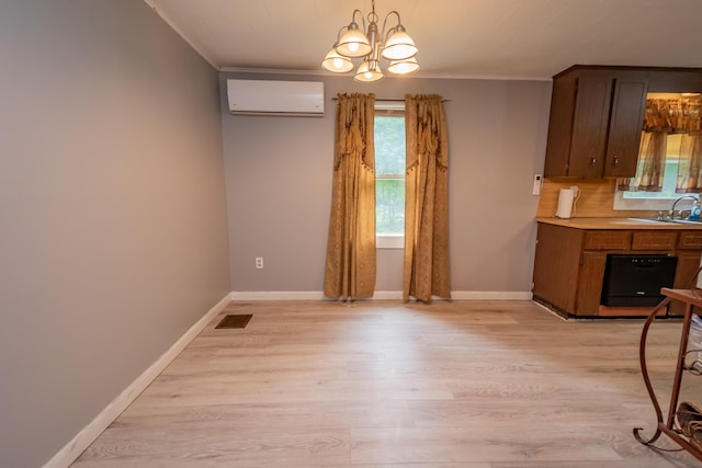 26 Knapp Ave, Milo, ME 04463 - kitchen featuring a wall mounted AC, a chandelier, light wood finished floors, light countertops, and a sink
