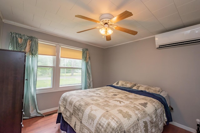 26 Knapp Ave, Milo, ME 04463 - bedroom featuring a wall unit AC, wood finished floors, baseboards, and ceiling fan