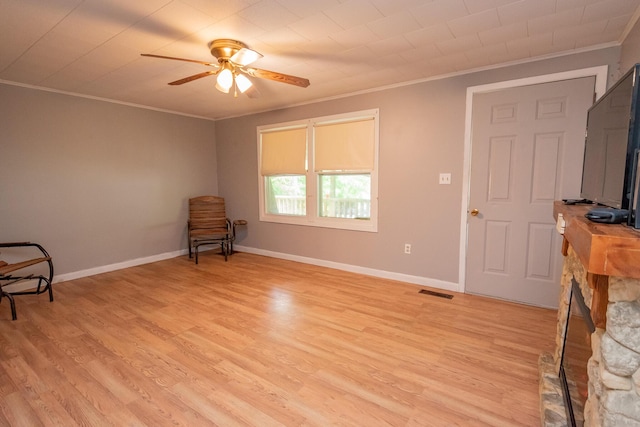 26 Knapp Ave, Milo, ME 04463 - unfurnished room with crown molding, ceiling fan, a stone fireplace, and light wood finished floors