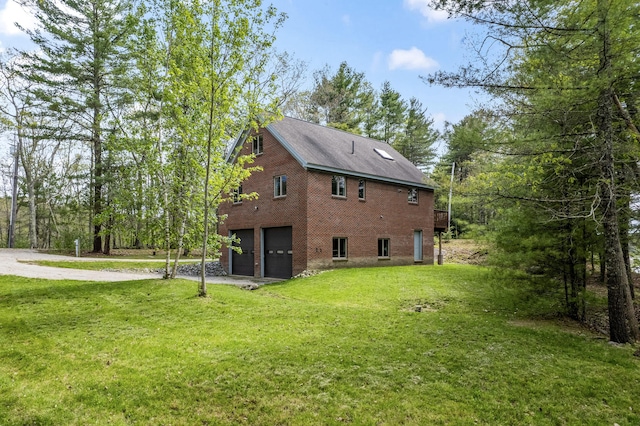 11 Pitch Pine Ln, Georgetown, ME 04548 - view of side of property with a garage, driveway, brick siding, and a yard