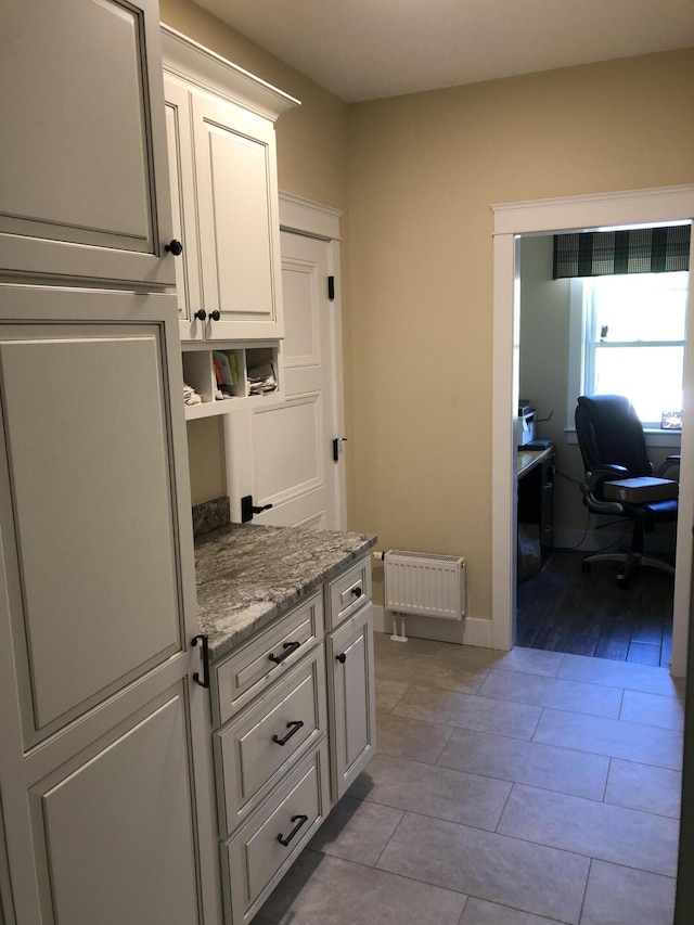 9 Atkinson Ln, Saco, ME 04072 - kitchen featuring radiator, white cabinets, light stone counters, and an office area