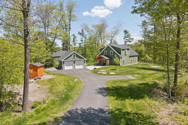 29 Bay Field Dr, Woolwich, ME 04579 - view of front of house with asphalt driveway, a front yard, and a storage unit