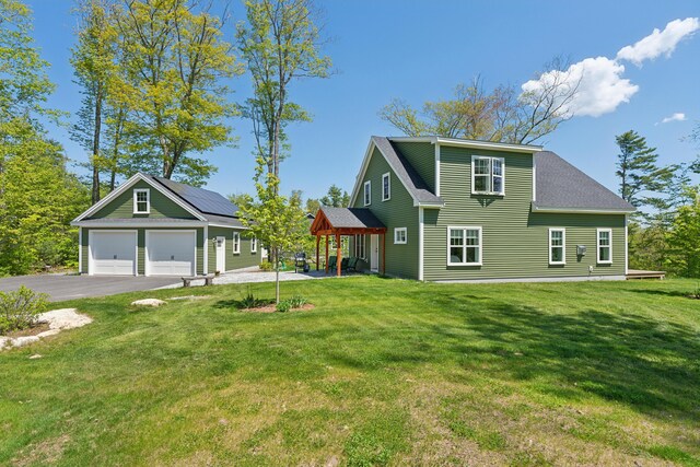29 Bay Field Dr, Woolwich, ME 04579 - view of front facade featuring a front yard, asphalt driveway, a shingled roof, and solar panels