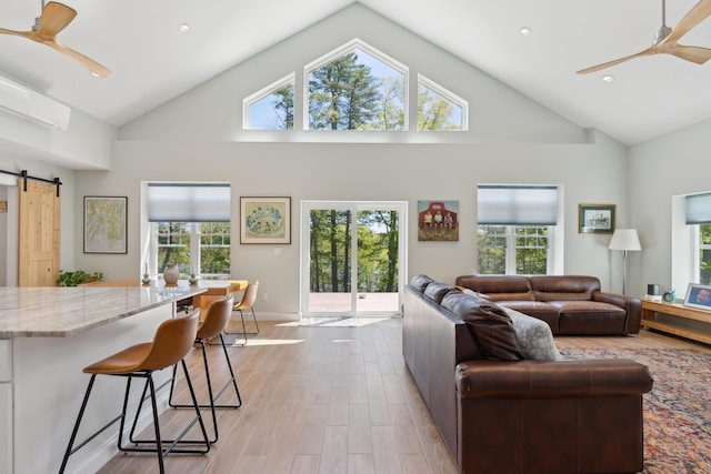 29 Bay Field Dr, Woolwich, ME 04579 - living area with ceiling fan, high vaulted ceiling, light wood-style flooring, healthy amount of natural light, and a barn door